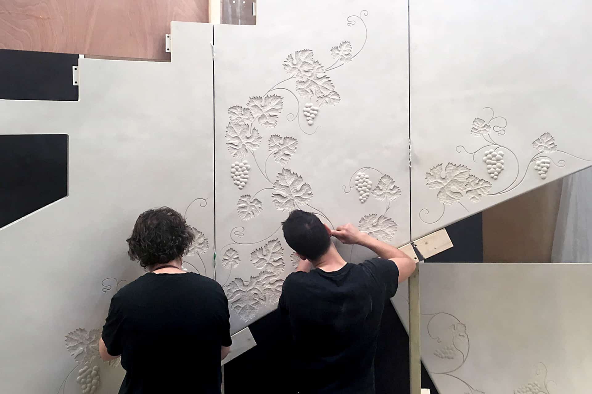 Work in progress on curved bas-relief panels. Photo by DKT Artworks.